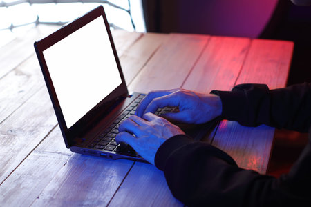 typing on laptop keyboard on table and colored background