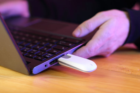 laptop with connected gsm modem on table and pink background