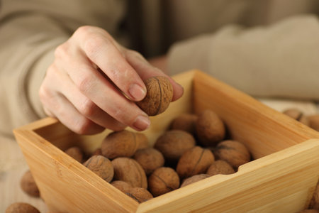 walnut in hand over wooden caseの写真素材