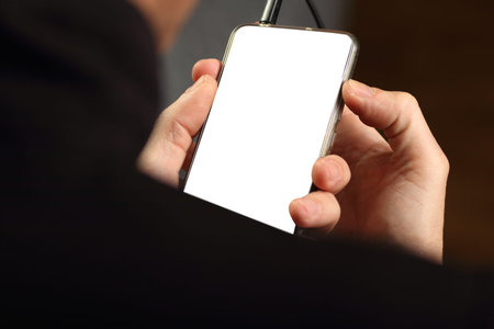 smartphone in hand with white screen on gray background
