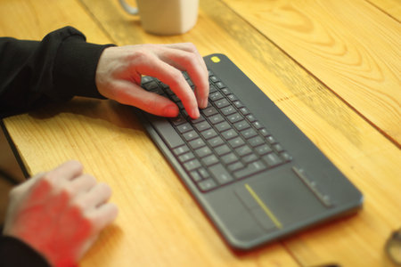typing on the keyboard to the tv by the person on the tableの写真素材