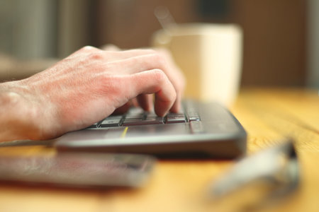 typing on the keyboard to the tv by the person on the table