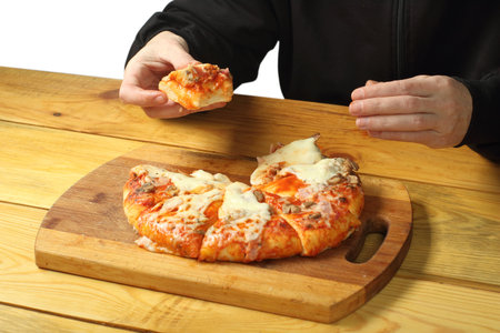 person holding a piece of pizza over the table and white backgroundの写真素材