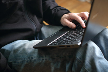 person is typing on a laptop keyboard