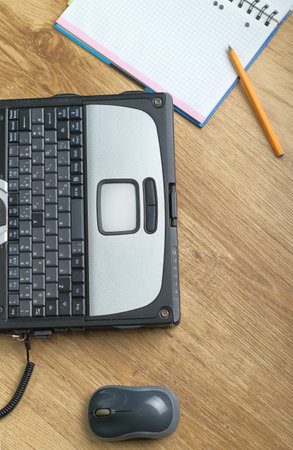 a laptop with a notebook and a pen on the panels next to the mouseの写真素材