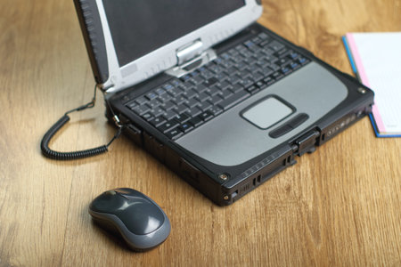 computer mouse next to the laptop on the panels