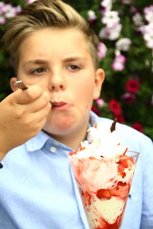 portrait of an young boy, eating ice and fruits, cup of ice and fruits,の写真素材