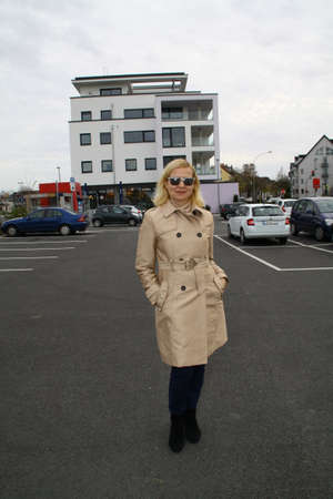 Portrait of an attractive lady in sunglasses posing in front of a parking lotの写真素材