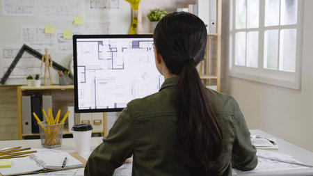 back view of young girl interior designer staring on monitor concentrated with creative idea...
