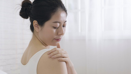 Close up of asian woman taking care of forearm applying cosmetic cream isolated on white background.の写真素材