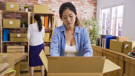 two young asian women in small start up business online shop owner working in office. girl employee...