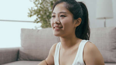 closeup attractive asian female in ponytail smiling contentedly. positive and confident image korean beautiful girl looking into distance and beaming with happiness.の写真素材