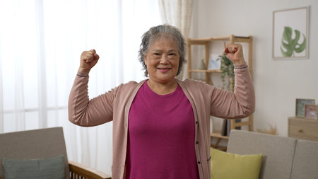 front portrait of a strong healthy asian senior old female looking at the camera with a  smile while...