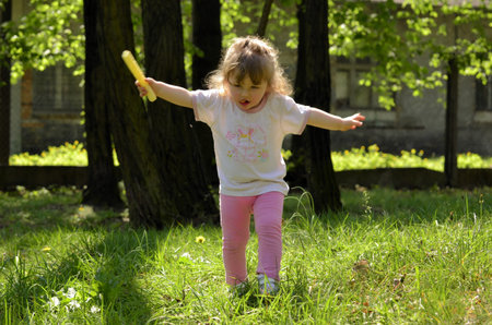 The photo shows a Little girl pretending to be a bird の写真素材