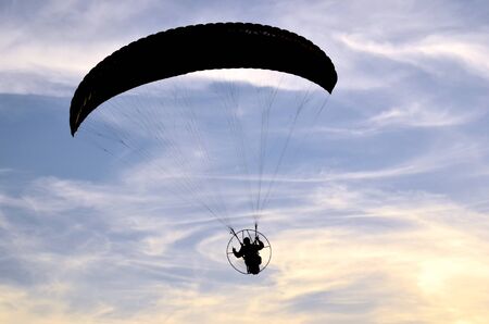 Photo shows a paraglider flies on a background of blue sky の写真素材