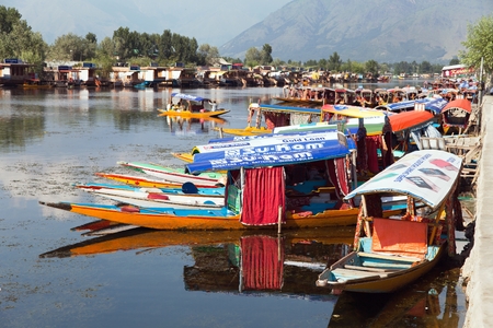 KASHMIR, INDIA - AUG 3 Shikara boats on Dal Lake with houseboats in Srinagar - Shikara is a small boat used for transportation in the Dal lake - 3rd of August 2013, Srinagar, Jammu and Kashmir, India のeditorial素材