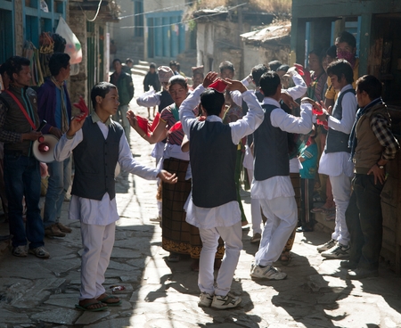 DUNAI, NEPAL, 2ND NOVEMBER 2013 - folkloric festival in Dunai village, young people dancink on street in garbs during festival - western Nepalのeditorial素材
