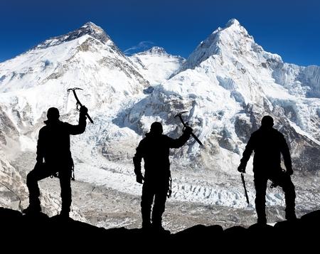 Silhouette of men with ice axe in hand, Mount Everest and Lhotse from Pumo Ri base camp - way to Everest base camp - Nepalの写真素材