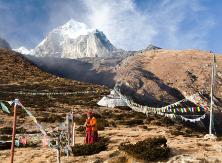 KHUMBU VALLEY, NEPAL - 8th NOVEMBER 2014 - Buddhist monk, stupa and prayer flags near Pangboche monastery and Tabuche peak, life in Khumbu valley on the way to Everest base campのeditorial素材