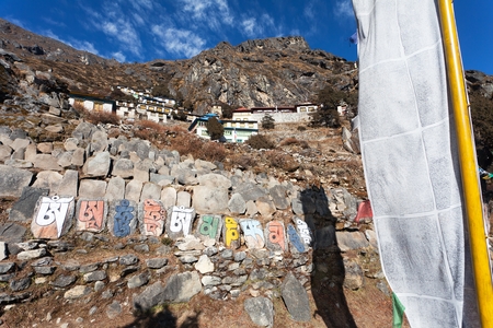 Thame gompa with prayer flags and buddhist symbols - monastery in Khumbu valley on three passes trek, Mount Everest area, Sagarmatha national park, Nepalese Himalayasの写真素材