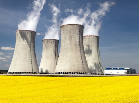 Nuclear power plant Dukovany with golden flowering field of rapeseed - Czech Republic - two possibility for production of energyの写真素材