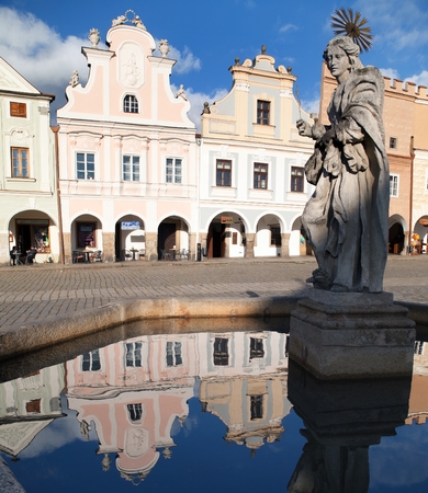 TELC, CZECH REPUBLIC, 28TH AUGUST 2015 - view of Telc or Teltsch town square, building mirroring in public fountain with statue of st. Margaret, Czech republic. World heritage site by unescoのeditorial素材