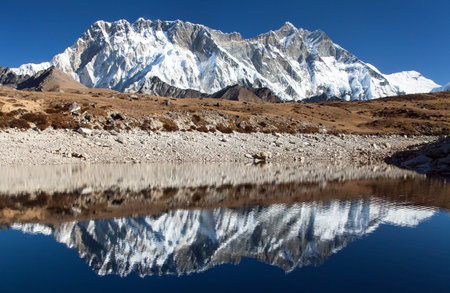Panoramic view of Lhotse and Nuptse south rock face mirroring in small lake, Everest area, Sagarmatha national park, Khumbu valley, Solukhumbu, Nepal Himalayas mountainsの写真素材