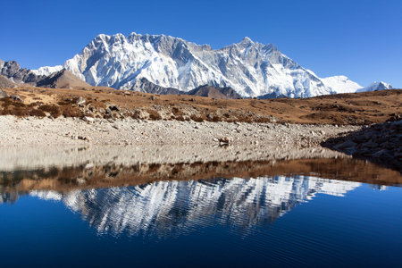 Panoramic view of Lhotse and Nuptse south rock face mirroring in small lake, Everest area, Sagarmatha national park, Khumbu valley, Solukhumbu, Nepal Himalayas mountainsの写真素材