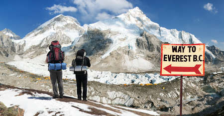 Panoramic view of Mount Everest base camp with two tourists and signpost way to Everest b.c. Sagarmatha national park, Khumbu valley Solukhumbu - Nepal Himalayas mountainsのeditorial素材