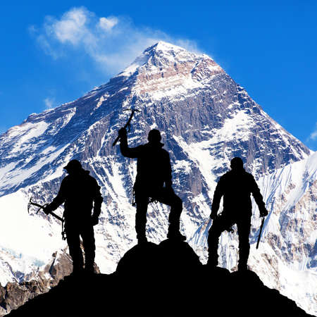 Mount Everest with black silhouette of three climbers with ice axe in hand on the way to Everest base camp, Khumbu valley Solukhumbu - Nepal Himalayas mountainsの写真素材
