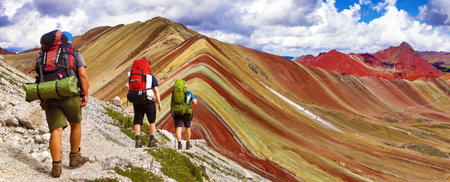 Rainbow mountains or Vinicunca Montana de Siete Colores with three tourists or hikers, Cuzco region in Peru, Peruvian Andesの写真素材