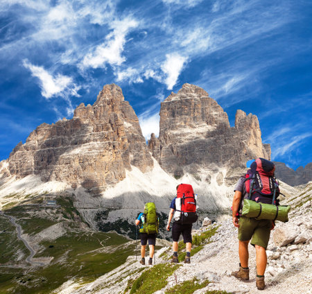 three hikers and Drei Zinnen or Tre Cime di Lavaredo, Sextener Dolomiten or Dolomiti di Sesto, South Tyrol, Dolomites mountains, Italien Alpsの写真素材
