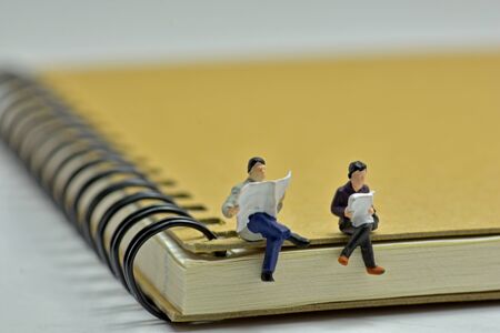 Concept, Read a book on a notebook, Men and women sit and read.の写真素材