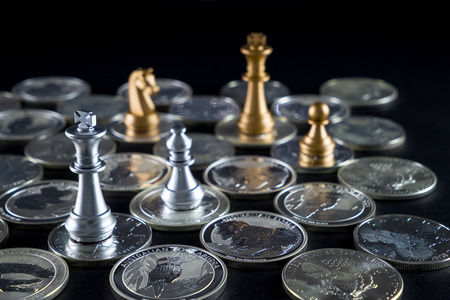 Silver chessboard, silver and gold chess, silver coins with black backgroundの写真素材