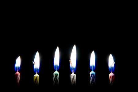 Burning six colorful candles with black background