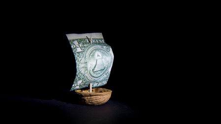 Dollar sailboat with black background, ship from the dollar and walnutの写真素材