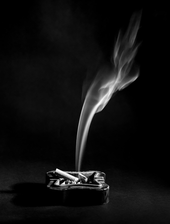 Ashtray and cigarette smoke, black and white detailの写真素材