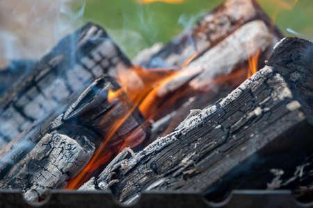 Close up of brightly burning wooden logs with yellow hot flames of fire.の写真素材