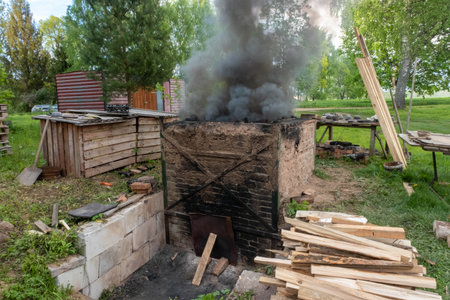 Firing of wood fire kiln is part of process for black pottery. Unique handmade pots and dishes of clay getting black after firing and oxygen reducing process in wood fire kiln. Latvian national craftsの写真素材