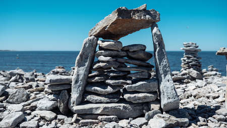 Stone figures on the beach of the Sorve Peninsula in the Ojessaare Nature Reserve. Estonia, Saaremaa. Horizon over sea in summer time. Pebble beachの写真素材