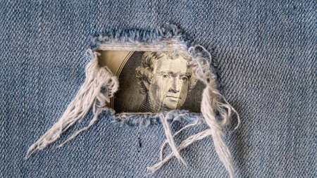 Poverty, hunger all over the world. Money in holey jeans pockets. two dollar bill. The world economy is sinkingの写真素材