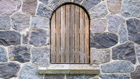 Old, boarded up window in the ruined wall of an old manor house in Latvia.の写真素材