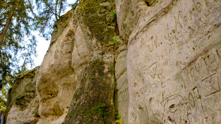 The large sandstone cliffs of Sietiniezis on the banks of the Gauja River in Latvia. tourist nature trail for hiking with wooden stairs. Gauja National Park in the vicinity of Valmiera, Autumn, Octoberの写真素材