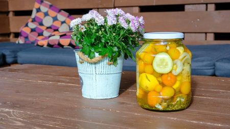 Canned and preserved tomatoes in a glass jar. Homemade pickled vegetables. Healthy fermented food....