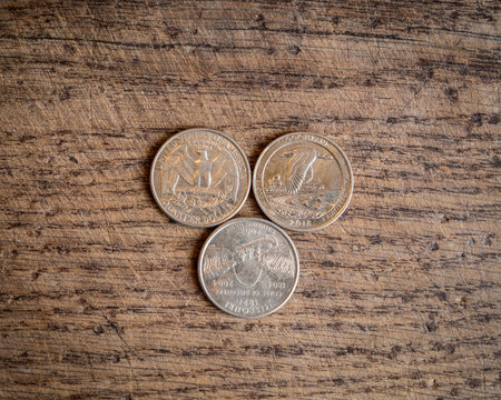 Close up of quarter dollar coins. Financial concept on wooden background.