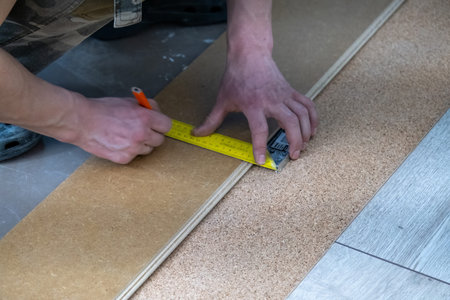 A man lays a laminate floor. Repair in the apartment. Laminate floor professionally installed.