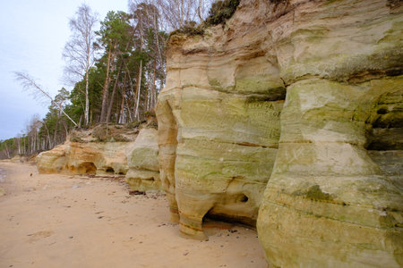 Beautiful in any weather, colorful sandstone cliffs. Beautiful coast of the Baltic Sea with caves. Veczemju klints, Veczemju cliffs in the Baltic Sea, Latvia.の写真素材