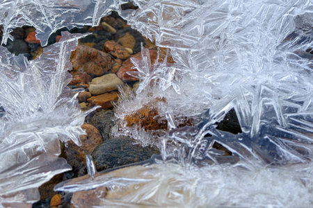 texture ice cracks, white ice crystals, winter frost background. Among the ice crystals are small...