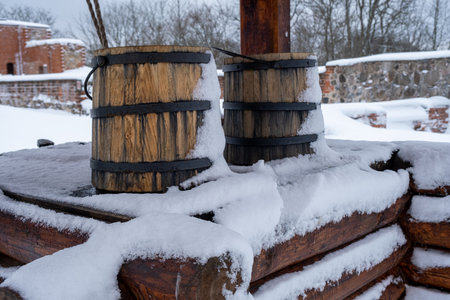 wooden bucket on the edge of the well in winter.の写真素材