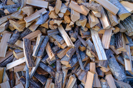A pile of stacked firewood, prepared for heating the house. Firewood for ready heating in...